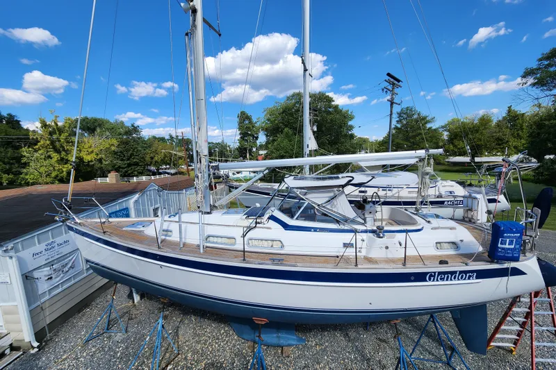 Slide: The Image of 2007 Hallberg-Rassy 37 sailboat on stands, clear sky, lush greenery background. - 2