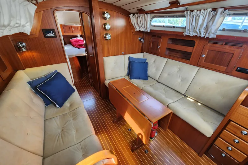 Slide: The Image of Interior of 2007 Hallberg-Rassy 37 yacht with cozy seating and wooden finishes. - 28