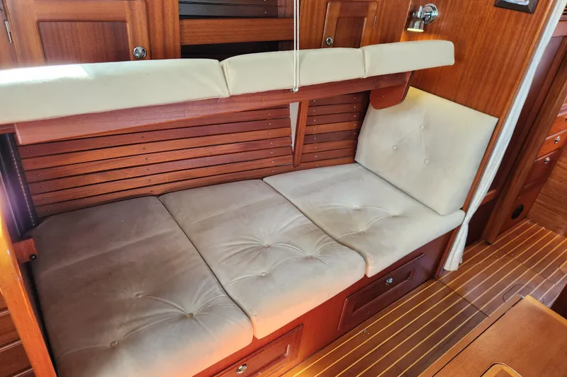 Slide: The Image of Interior of a 2007 Hallberg-Rassy 37 yacht with cushioned seating and wooden paneling. - 29