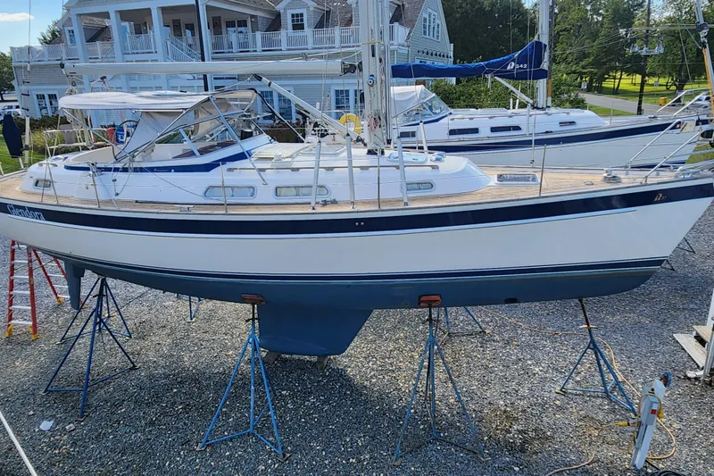 Slide: The Image of 2007 Hallberg-Rassy 37 sailboat on stands, with a scenic marina backdrop. - 3