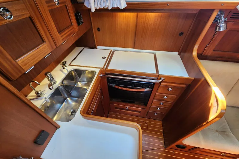 Slide: The Image of Hallberg-Rassy 37 (2007) yacht kitchen with wooden cabinetry and stainless steel sink. - 31