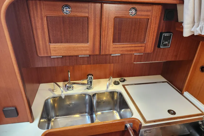 Slide: The Image of Galley of 2007 Hallberg-Rassy 37 yacht with wooden cabinets and double sink. - 32