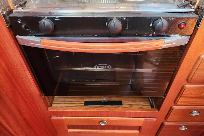 Slide: The Image of Built-in oven in 2007 Hallberg-Rassy 37 yacht kitchen, featuring wooden cabinetry. - 35