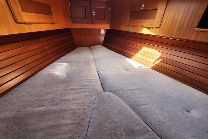 Slide: The Image of Cozy cabin interior of 2007 Hallberg-Rassy 37 sailboat with wooden paneling and cushioned berth. - 36