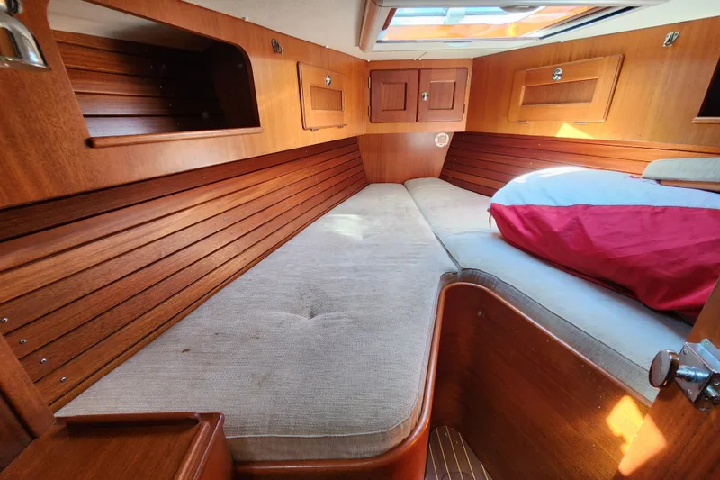 Slide: The Image of Cozy cabin interior of 2007 Hallberg-Rassy 37 sailboat with wooden finish and bedding. - 37