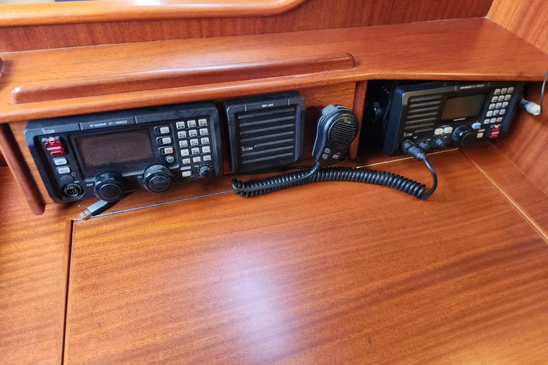 Slide: The Image of 2007 Hallberg-Rassy 37 yacht radio equipment with Icom communication devices on wooden panel. - 42