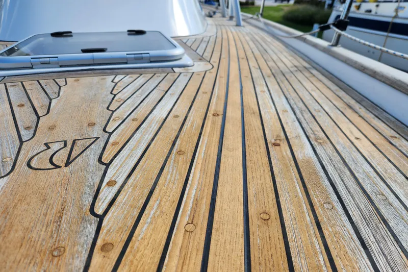 Slide: The Image of Teak deck of 2007 Hallberg-Rassy 37 sailboat, featuring intricate wood patterns and hatch. - 9