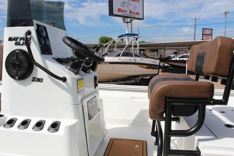 Slide: The Image of 2026 Excel Bay Pro Elite 230 boat interior with steering console and seating. - 10
