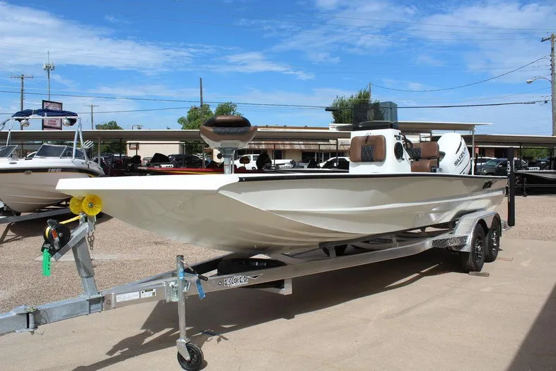 Slide: The Image of 2026 Excel Bay Pro Elite 230 boat on trailer, displayed outdoors under clear sky. - 13