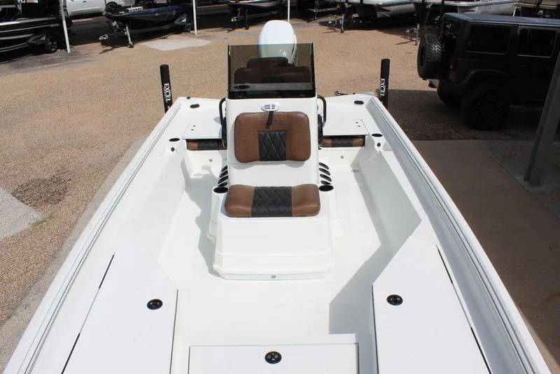 Slide: The Image of 2026 Excel Bay Pro Elite 230 boat with brown seating, parked outdoors. - 14