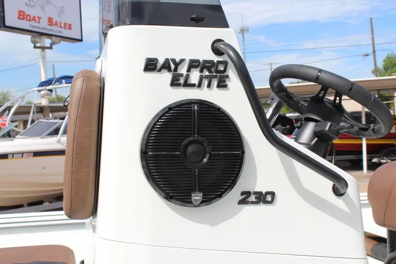 Slide: The Image of 2026 Excel Bay Pro Elite 230 boat console with steering wheel and speaker. - 16