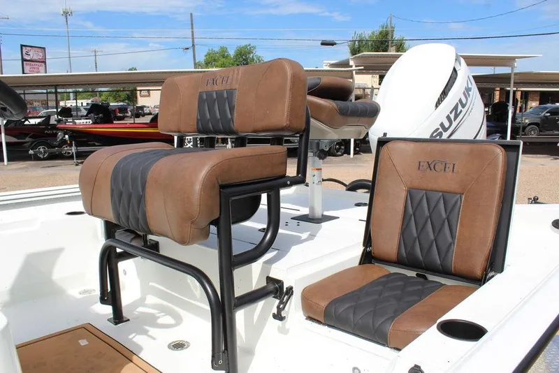 Slide: The Image of 2026 Excel Bay Pro Elite 230 boat seats with brown and black upholstery, featuring Suzuki engine. - 18