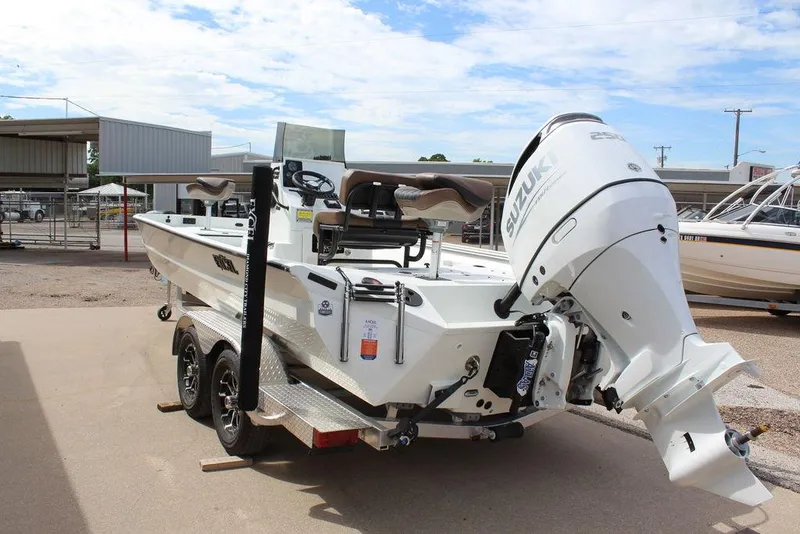 Slide: The Image of 2026 Excel Bay Pro Elite 230 boat with Suzuki outboard motor, parked on a trailer. - 2