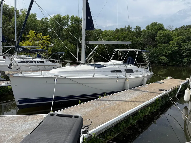 The Image of Sailboat docked at marina, Hunter 33 model, 2005, surrounded by lush greenery. - 1