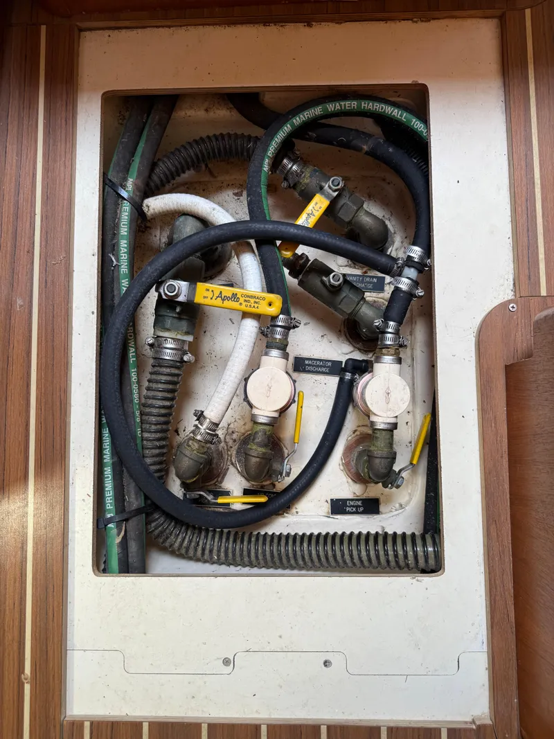 Slide: The Image of Plumbing system inside a 2005 Hunter 33 boat, featuring hoses and valves. - 12