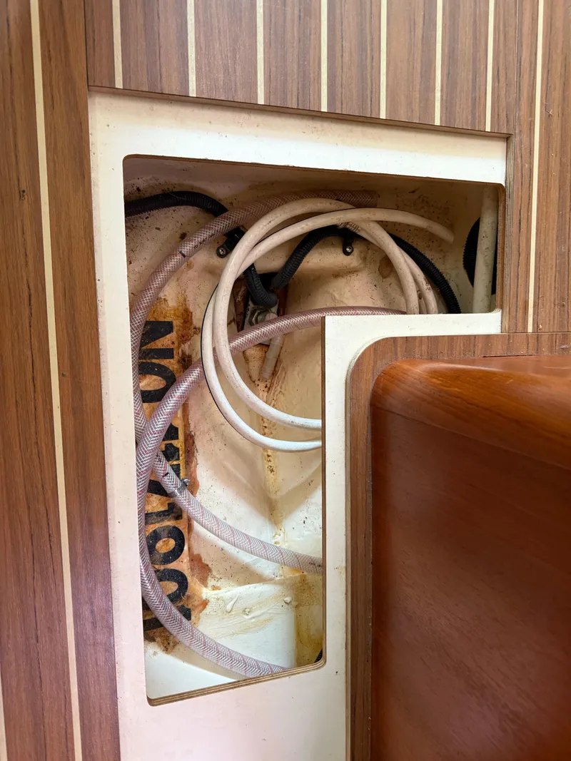 Slide: The Image of Interior view of a 2005 Hunter 33 sailboat showing wiring and wood paneling. - 15
