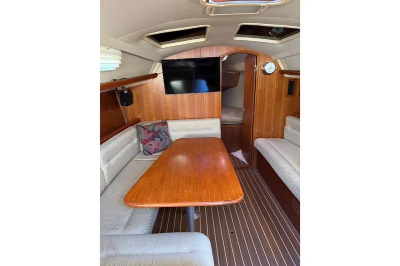 Slide: The Image of Interior of 2005 Hunter 33 sailboat with wood finish and cozy seating area. - 17