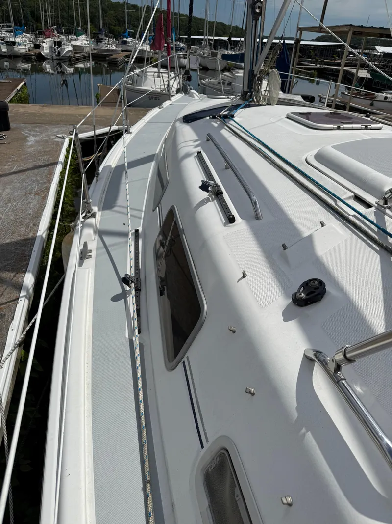 Slide: The Image of 2005 Hunter 33 sailboat docked at a marina, showcasing deck and rigging. - 4