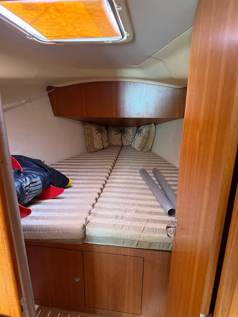 Slide: The Image of Cozy cabin interior of 2005 Hunter 33 sailboat with striped bedding and wooden finish. - 6