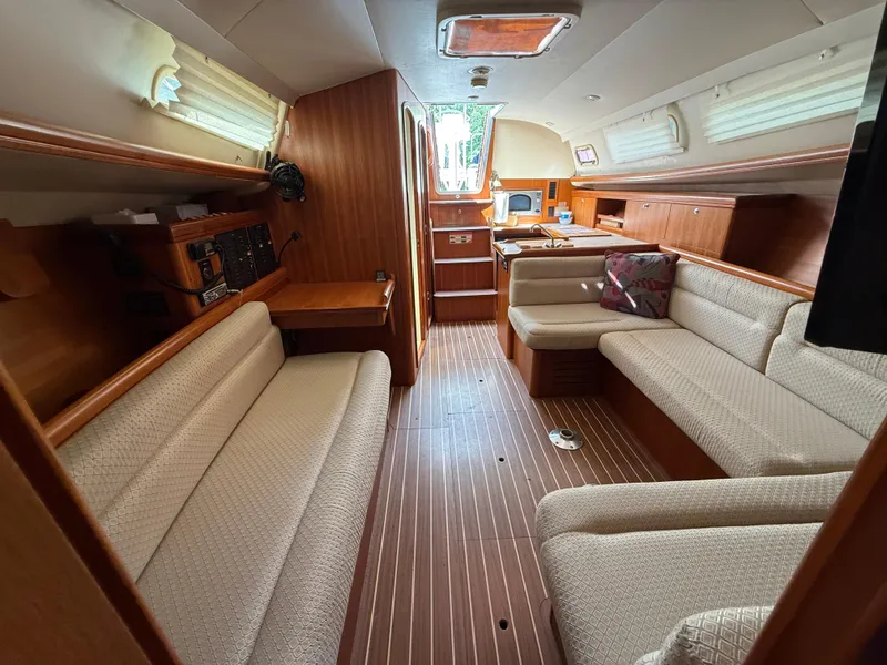 Slide: The Image of Interior of a 2005 Hunter 33 sailboat with cozy seating and wooden finishes. - 7