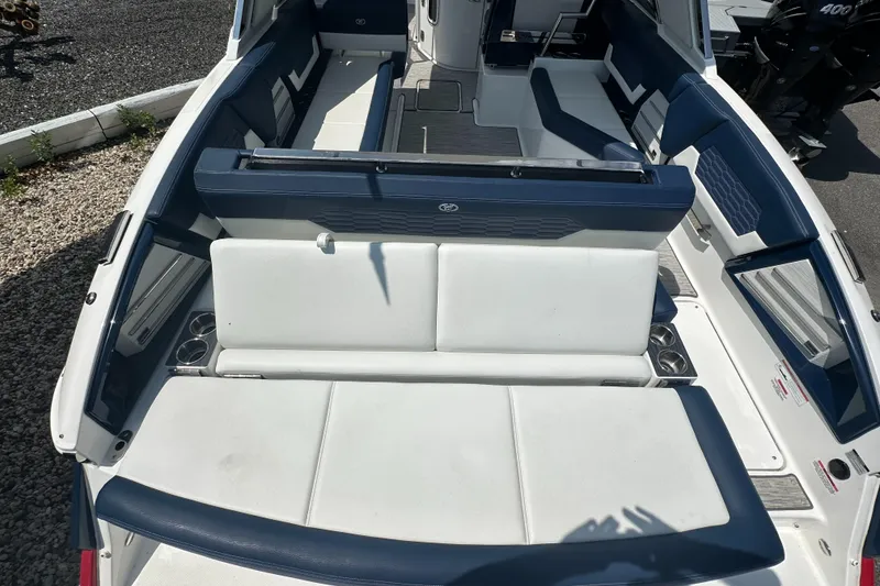 Slide: The Image of 2022 Cobalt A29 boat interior with white and blue seating, cup holders, and sleek design. - 7