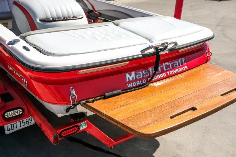 Slide: The Image of 2002 MasterCraft ProStar 197 boat with wooden swim platform, red and white design. - 4