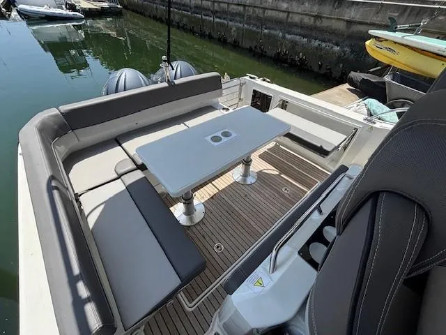 Slide: The Image of 2023 Jeanneau Leader 9.0 WA boat with spacious seating and table on deck. - 13