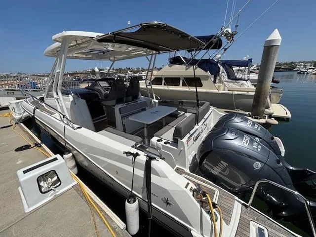 Slide: The Image of 2023 Jeanneau Leader 9.0 WA boat docked with twin engines and shaded seating area. - 16