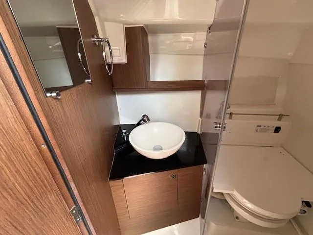 Slide: The Image of 2023 Jeanneau Leader 9.0 WA bathroom with modern sink and wooden cabinetry. - 25