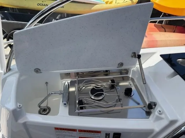 Slide: The Image of 2023 Jeanneau Leader 9.0 WA boat with open stove compartment. - 26