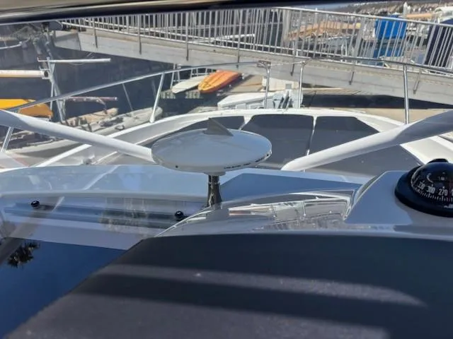 Slide: The Image of 2023 Jeanneau Leader 9.0 WA boat deck with navigation equipment and marina view. - 28