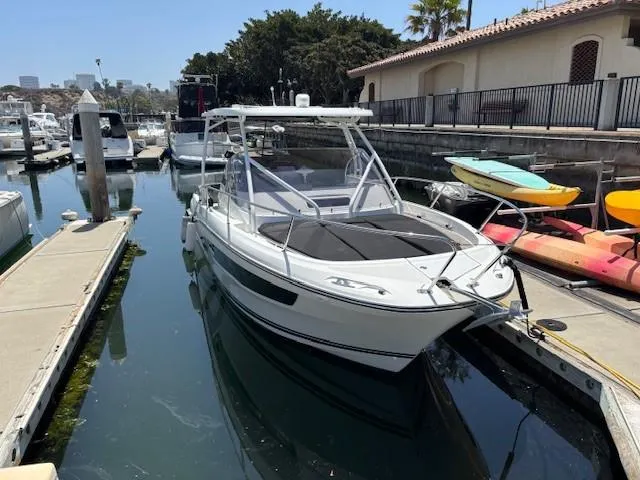 Slide: The Image of 2023 Jeanneau Leader 9.0 WA boat docked in a marina, surrounded by kayaks. - 33