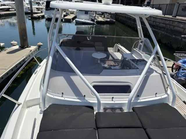 Slide: The Image of 2023 Jeanneau Leader 9.0 WA boat docked in marina, featuring spacious deck and seating area. - 36