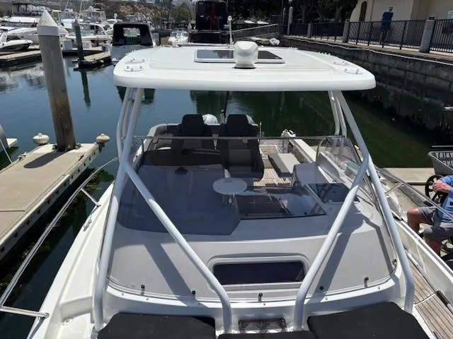 Slide: The Image of 2023 Jeanneau Leader 9.0 WA boat docked at marina, showcasing sleek design and spacious deck. - 37