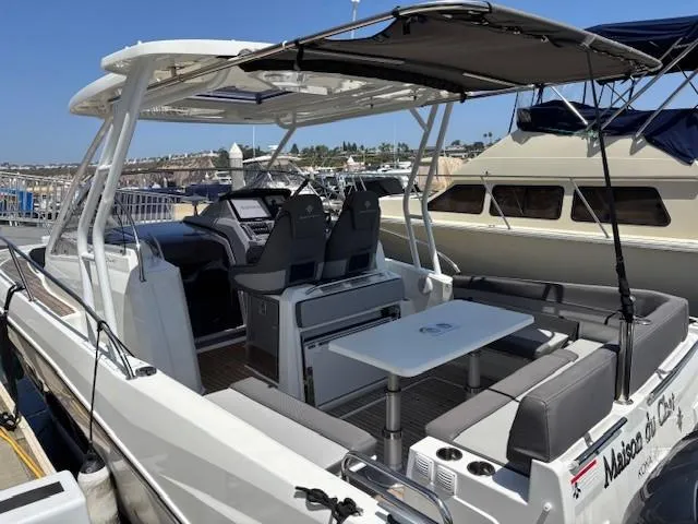 Slide: The Image of 2023 Jeanneau Leader 9.0 WA boat docked, featuring spacious seating and modern design. - 9