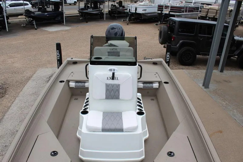 Slide: The Image of 2026 Excel Bay Pro Elite 203 boat, beige interior, parked in a lot with other vehicles. - 5