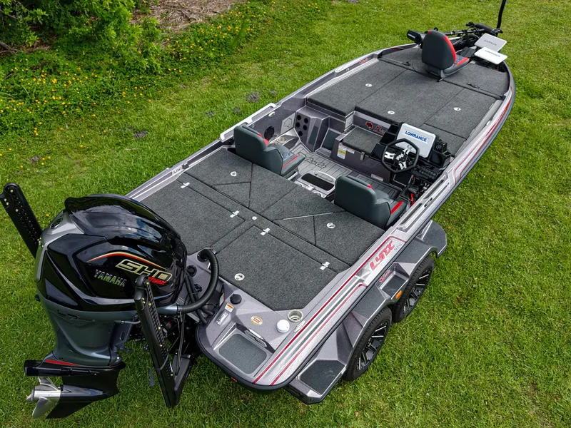 Slide: The Image of 2026 Bass Cat Lynx STS fishing boat with Yamaha engine on grassy background. - 16