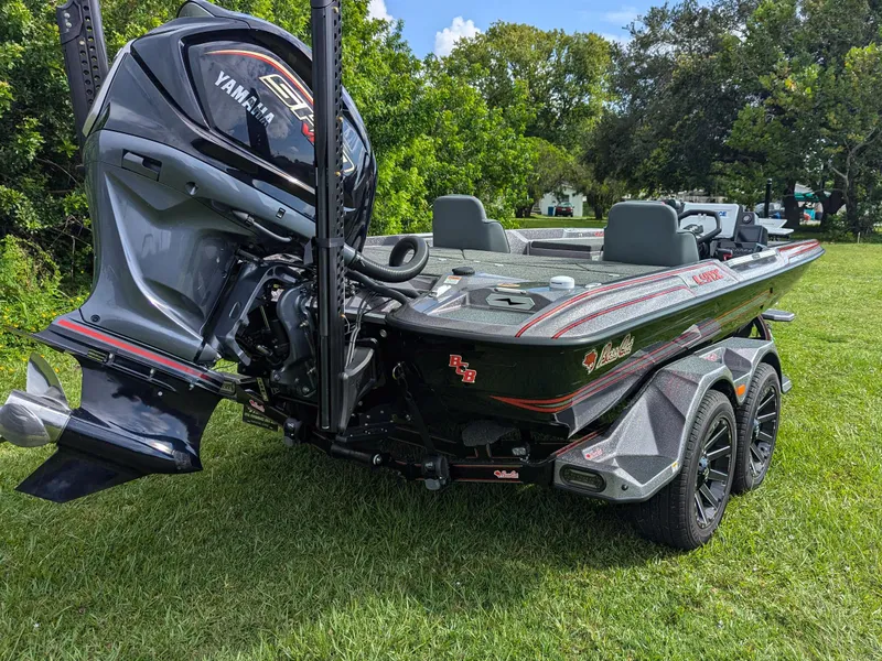Slide: The Image of 2026 Bass Cat Lynx STS boat with Yamaha engine on grassy field. - 3