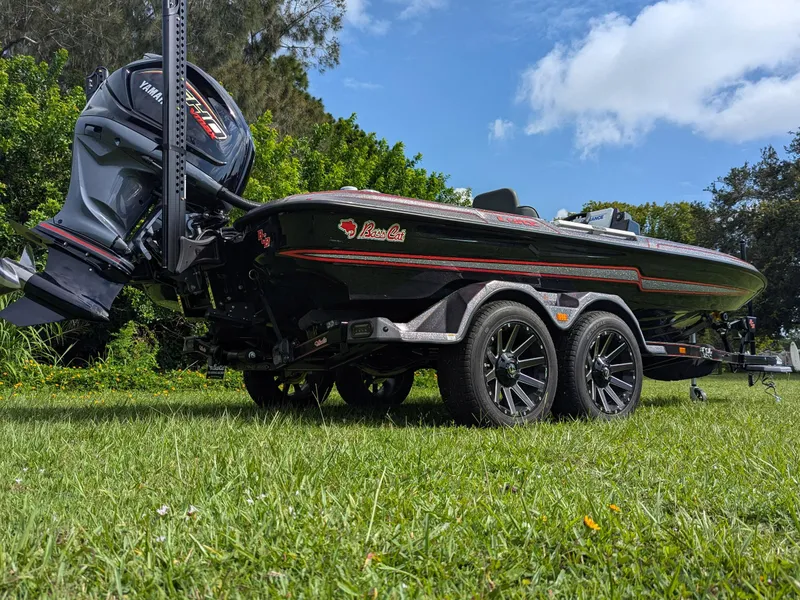 Slide: The Image of 2026 Bass Cat Lynx STS boat on trailer, grassy field, Yamaha motor, sunny day. - 4