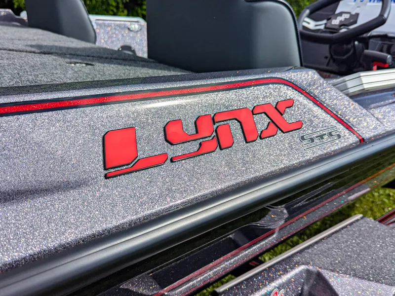 Slide: The Image of 2026 Bass Cat Lynx STS boat with metallic finish and red logo detailing. - 6