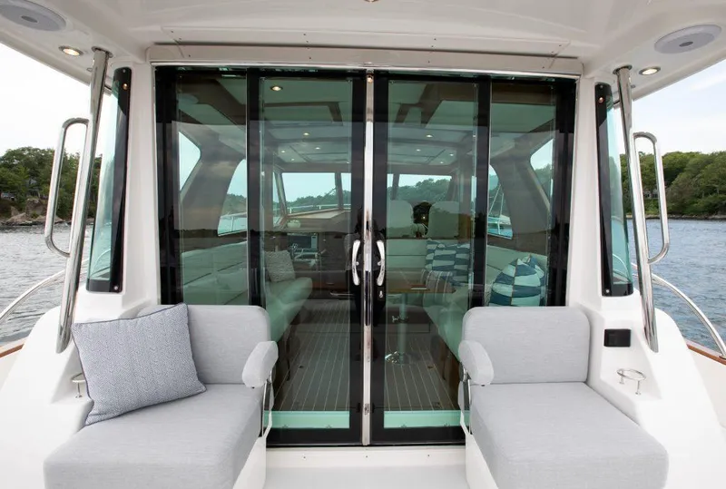 Slide: The Image of 2026 Sabre 43 Salon Express yacht interior with sliding glass doors and cushioned seating. - 9