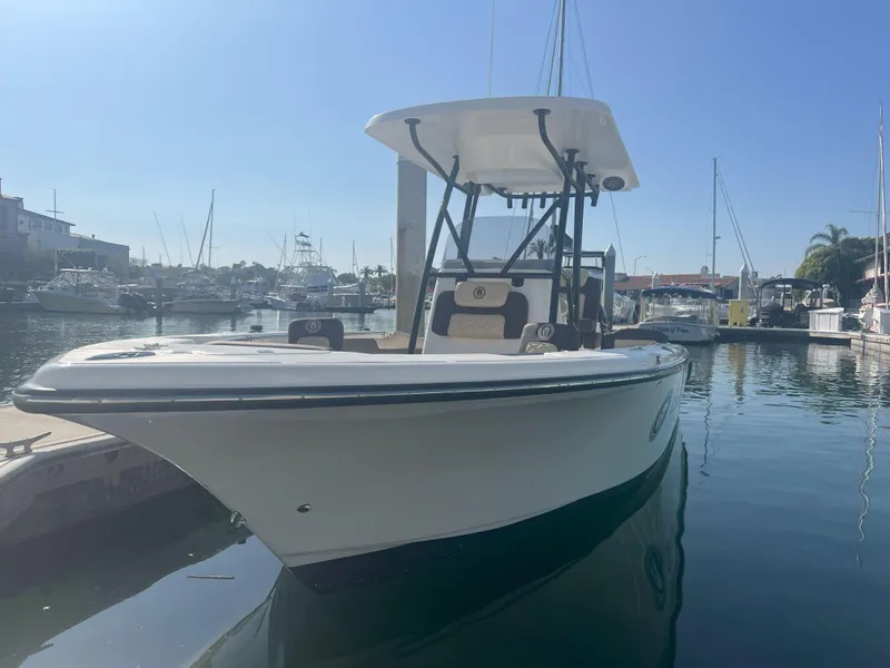 Slide: The Image of 2026 Reflex Gladiator 2400 boat docked in a marina under clear blue sky. - 12
