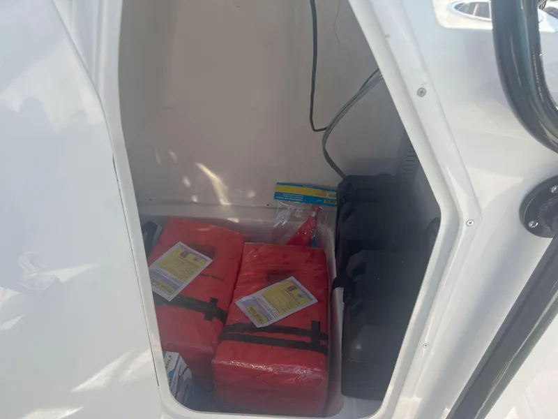 Slide: The Image of Storage compartment in Reflex Gladiator 2400 boat, containing safety equipment and supplies. - 17