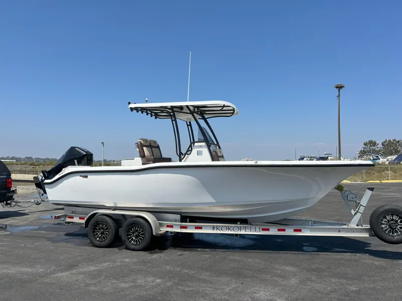 Slide: The Image of 2026 Reflex Gladiator 2400 boat on trailer, parked outdoors under clear blue sky. - 2