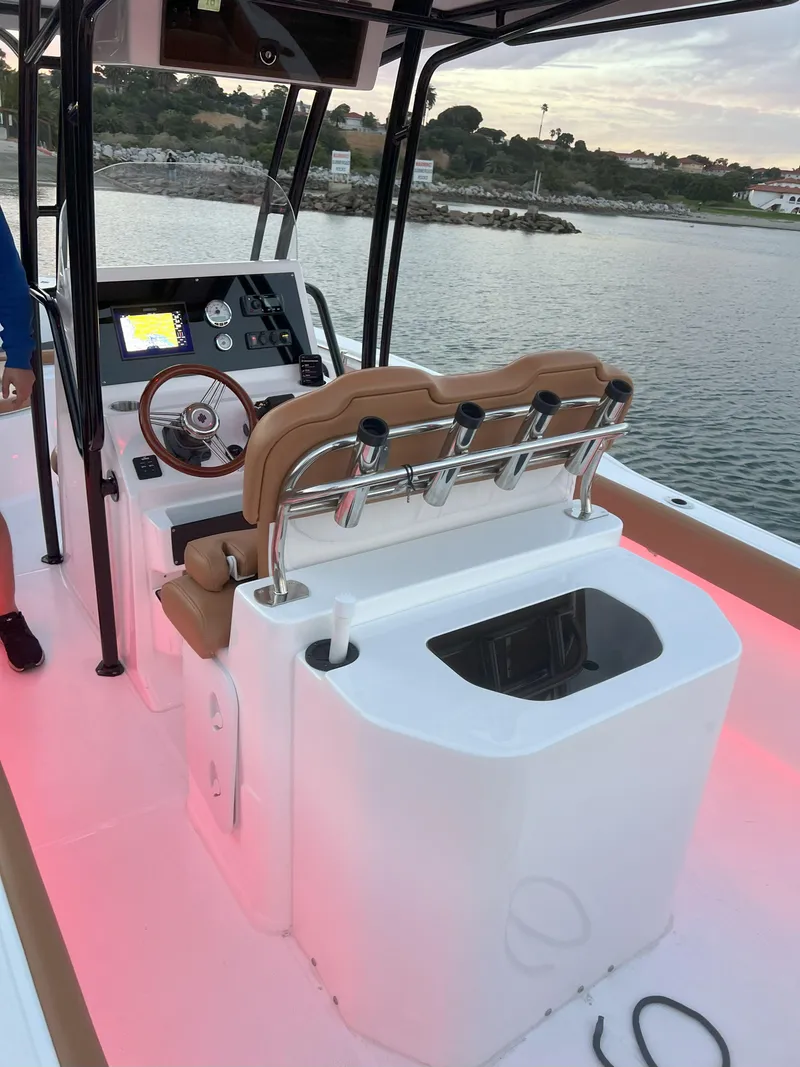 Slide: The Image of 2026 Reflex Gladiator 2400 boat interior with modern dashboard and seating, illuminated by pink lights. - 42