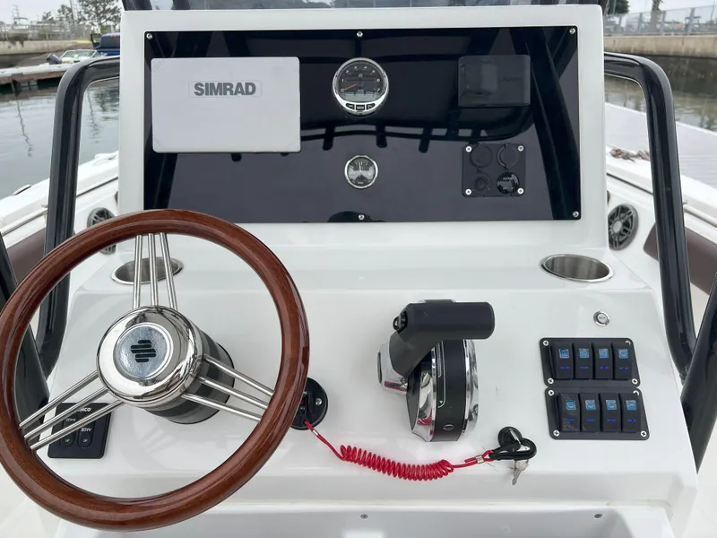 Slide: The Image of Boat dashboard with steering wheel, controls, and Simrad display on Reflex Gladiator 2400, 2026 model. - 44