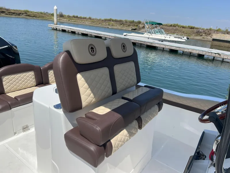 Slide: The Image of Luxurious seating on 2026 Reflex Gladiator 2400 boat, docked by serene waters. - 47