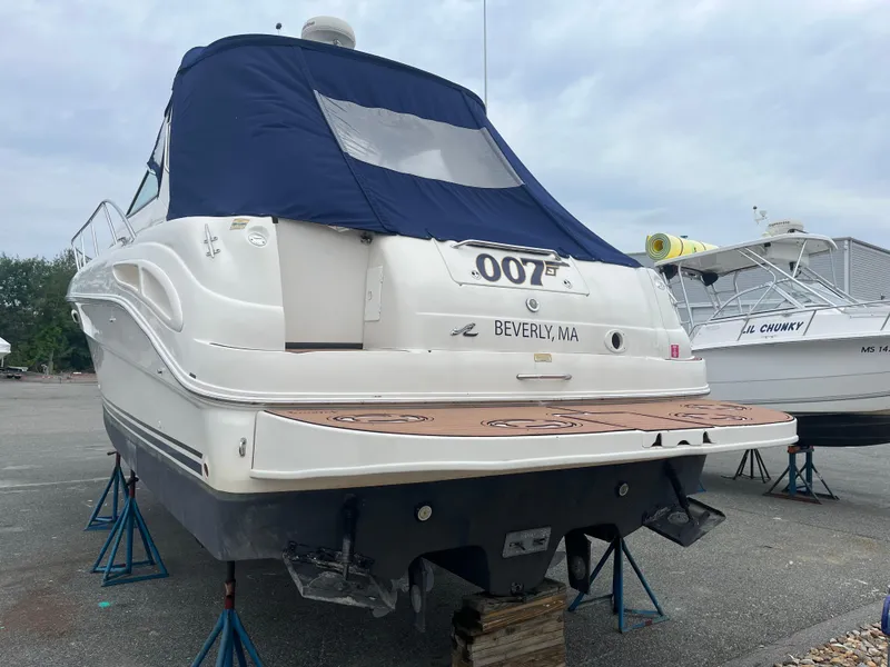 Slide: The Image of 2000 Sea Ray 340 Sundancer boat on stands, rear view, with blue cover, in Beverly, MA. - 12