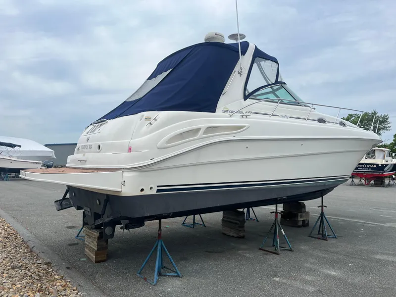 Slide: The Image of 2000 Sea Ray 340 Sundancer boat on stands, covered with a blue canopy. - 14