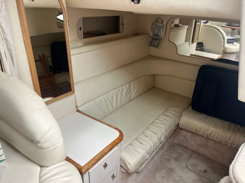 Slide: The Image of Interior of 2000 Sea Ray 340 Sundancer with cream leather seating and wooden accents. - 22